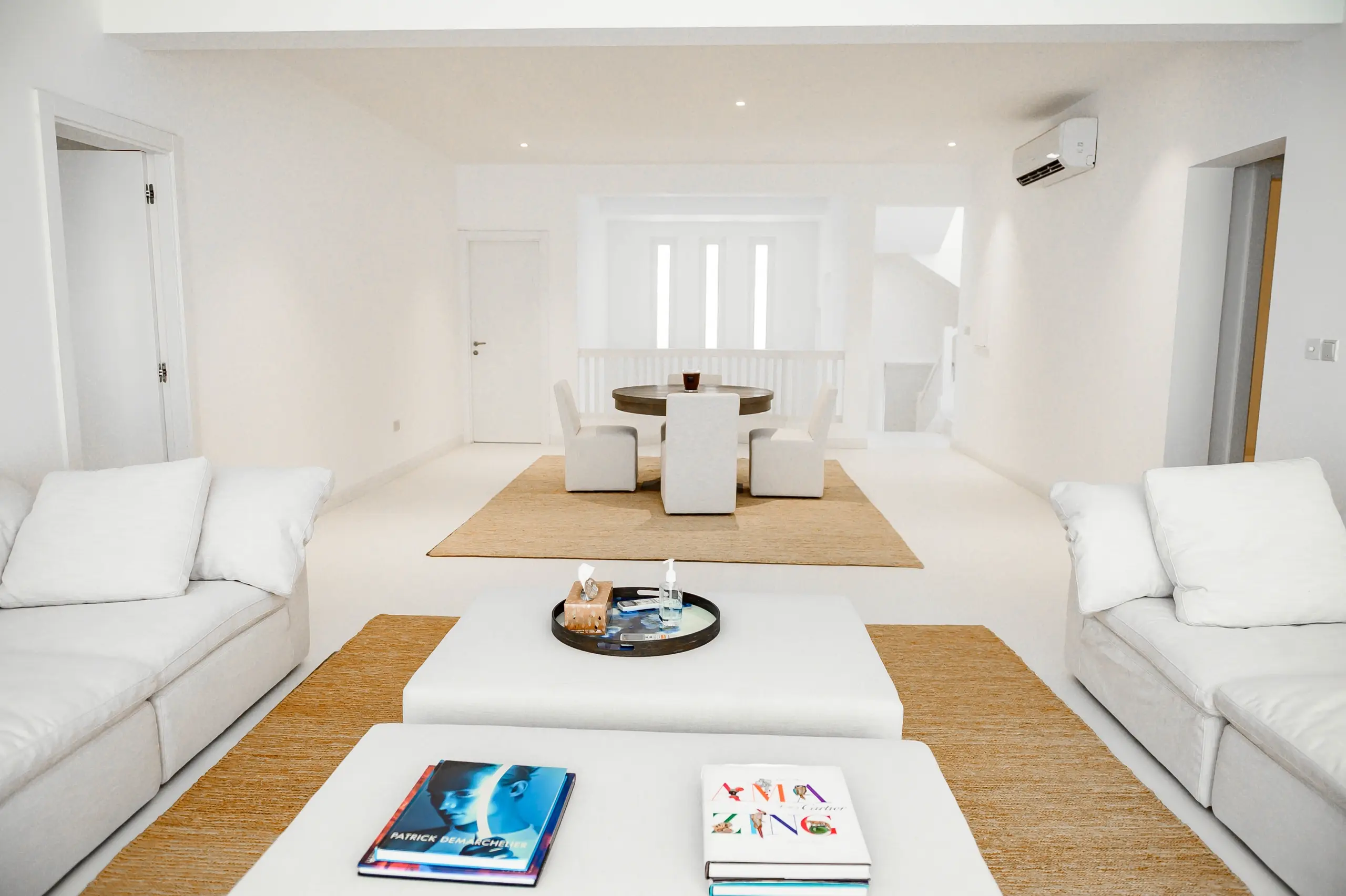 White living room with sofas and dining area