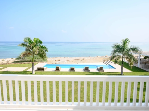 A beautiful beachfront pool area with palm trees