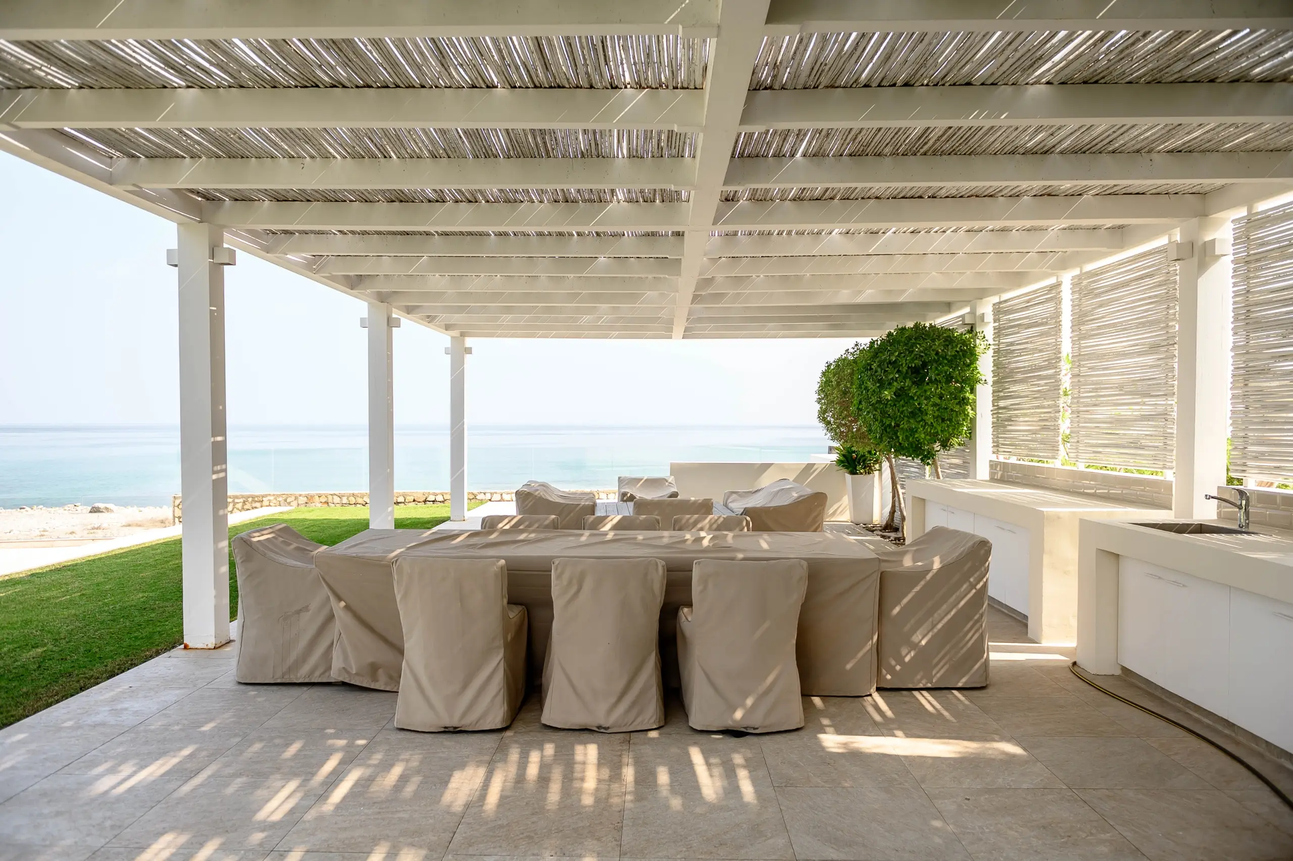 A shaded outdoor dining area with ocean view