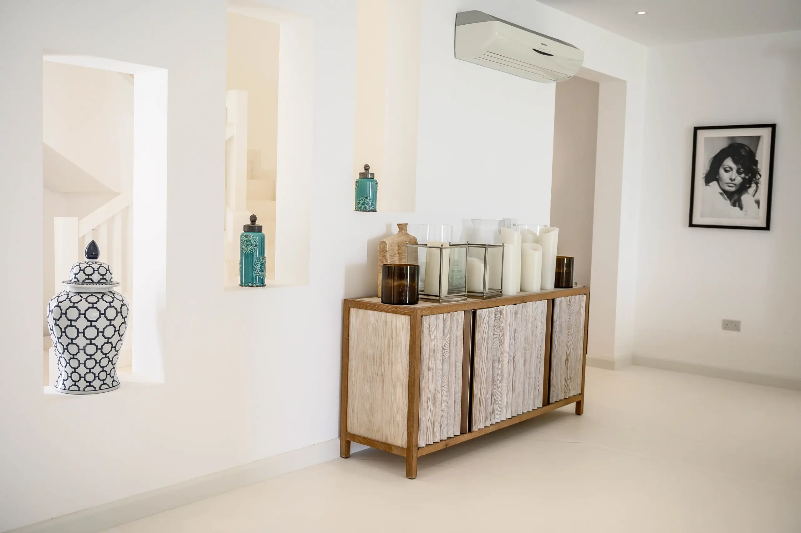 White entryway with wood cabinet and decor